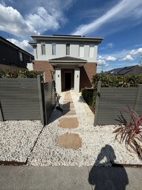 Modern home entry with stepping stones and pebble front garden